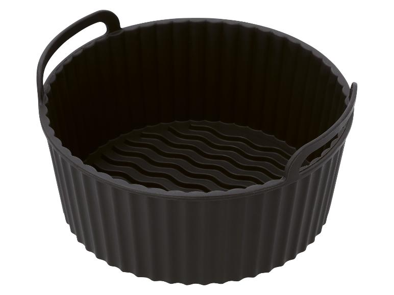 Panier en silicone noir pour friteuse à air avec fond ondulé et poignées.