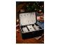 Un coffret à bijoux en velours noir avec des colliers et des bagues.