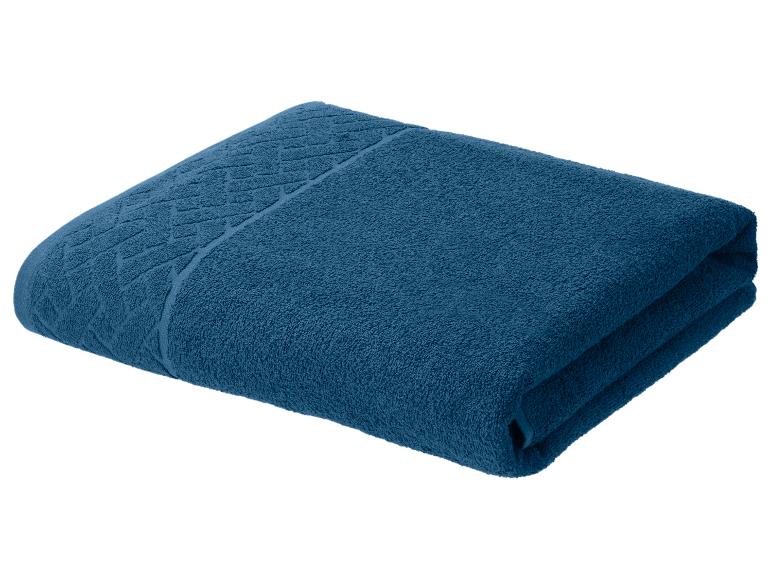 Serviette en coton bleu marine pliée avec motif décoratif