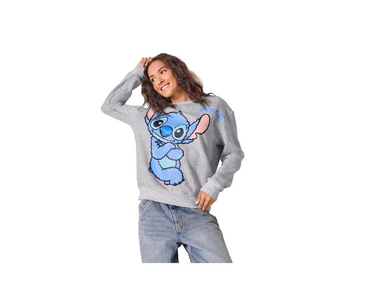 Femme en sweat-shirt gris avec imprimé Stitch et jean.