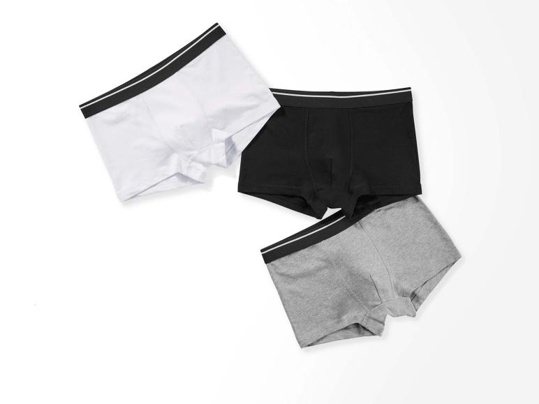 Trois paires de boxers en blanc, noir et gris.