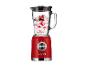 Un blender rouge style années 1970 avec un bol en verre rempli de fruits rouges et de yaourt.
