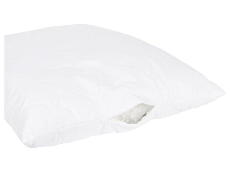 Oreiller blanc matelassé avec fermeture éclair, garnissage en fibres.