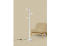 Lampadaire blanc à trois spots à côté d'un fauteuil beige.
