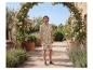 Homme en chemise et short beiges à motif de feuilles, dans un jardin.