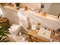Salle de bain lumineuse avec accessoires en bois et blancs, toilettes et lavabo.