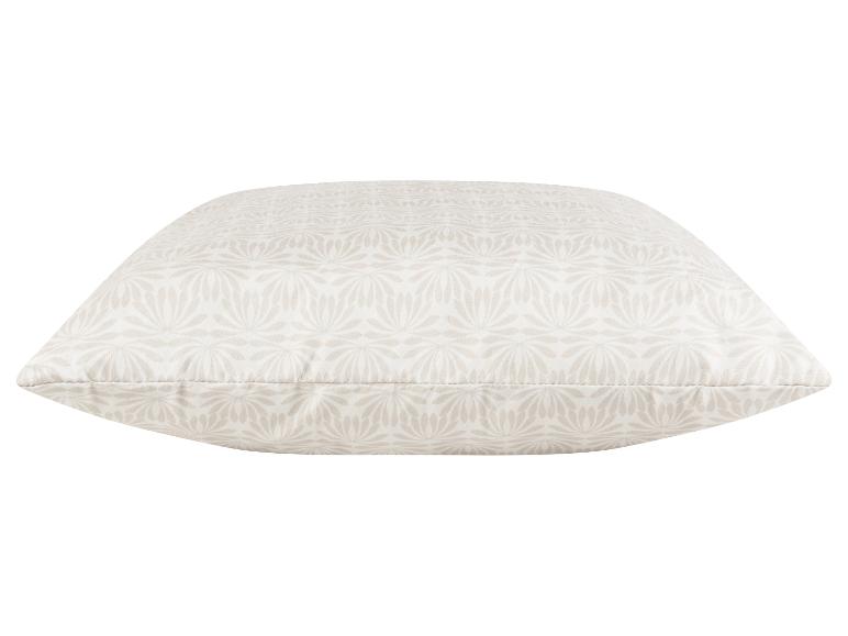 Coussin décoratif beige à motif floral.
