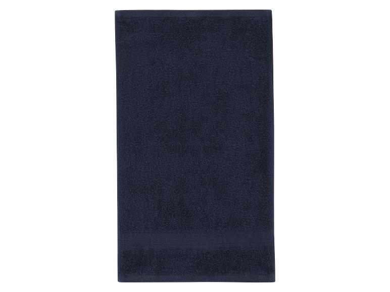 Serviette de bain bleu foncé pliée sur fond blanc