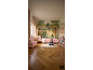 Chambre d'enfant avec lit cabane, fille lisant et papier peint forêt.