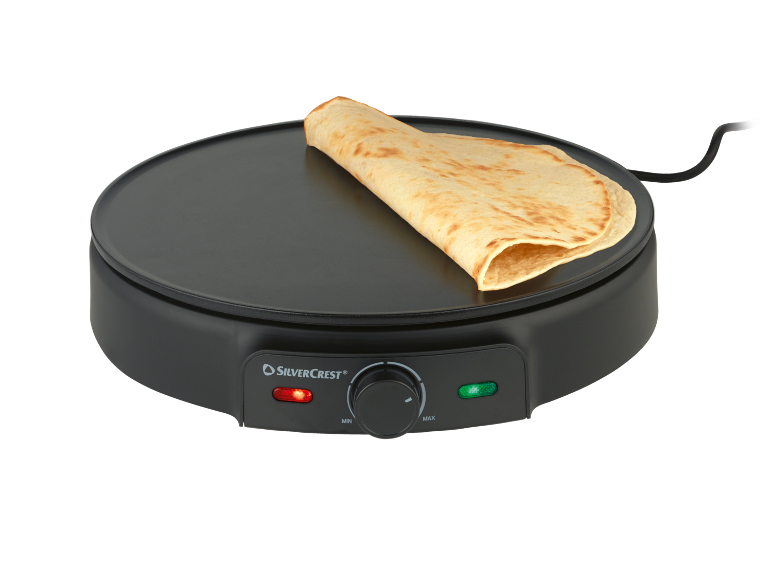 Crêpière noire avec crêpe, avec bouton de température et voyants lumineux.