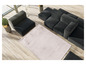 Un tapis beige avec un canapé modulaire noir.