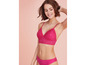 Une femme portant un soutien-gorge rose et une culotte assortie en dentelle.