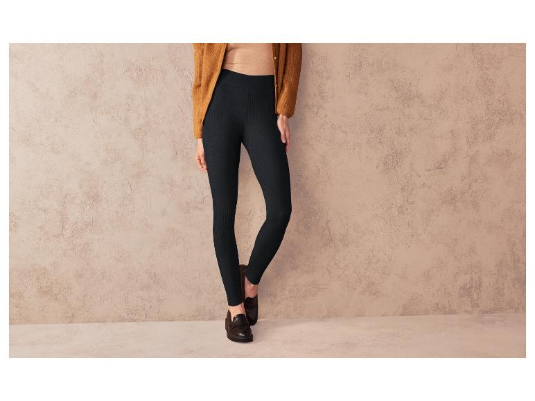 Leggings noirs à côtes, portés avec un pull beige et des mocassins noirs.
