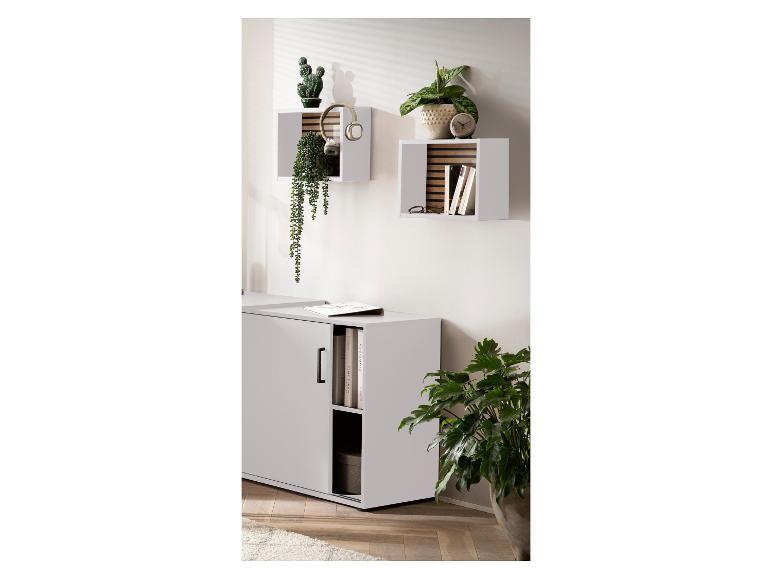 Salon avec étagères murales blanches, plantes et buffet blanc à porte coulissante.