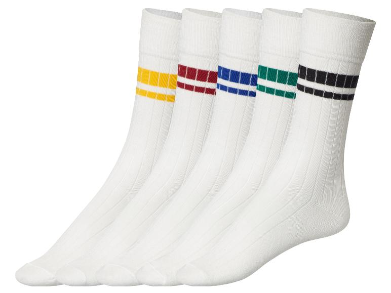 Quatre paires de chaussettes blanches avec des rayures colorées.