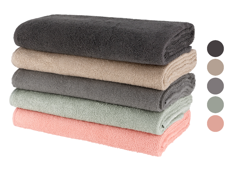 Une pile de serviettes de bain de couleurs neutres.