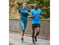 Deux personnes courent en vêtements de sport, y compris un t-shirt bleu et un short noir.