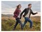 Homme et femme dans un paysage naturel, portant des doudounes et des jeans.
