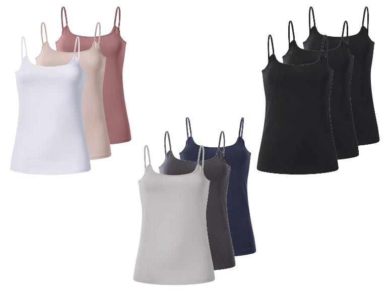 Lot de neuf débardeurs à fines bretelles pour femme en blanc, beige, rose, gris, bleu foncé et noir.