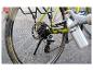 Main gantée lubrifiant une chaîne de vélo avec un spray Parkside.