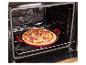 Pizza fraîchement préparée dans un plat de cuisson rouge, placée dans un four ouvert.
