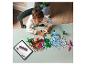 Un enfant construit avec des briques LEGO sur une table, suivant les instructions sur une tablette.