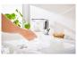Lavabo, robinet chromé et brosse à récurer en bambou.
