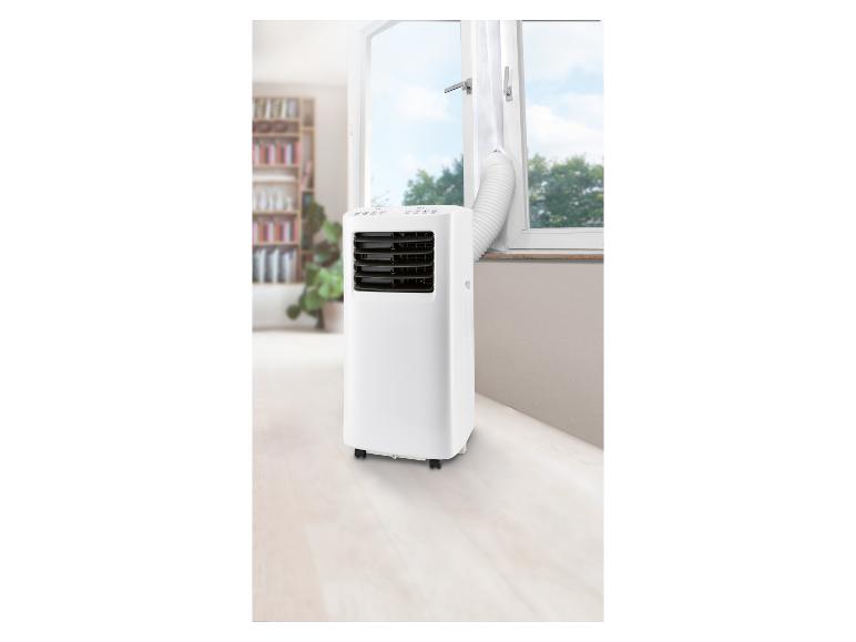 Climatiseur mobile blanc avec tuyau d'évacuation dirigé vers l'extérieur par une fenêtre ouverte.