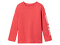 Un t-shirt rouge à manches longues avec l'inscription 'Good Vibes' sur la manche.