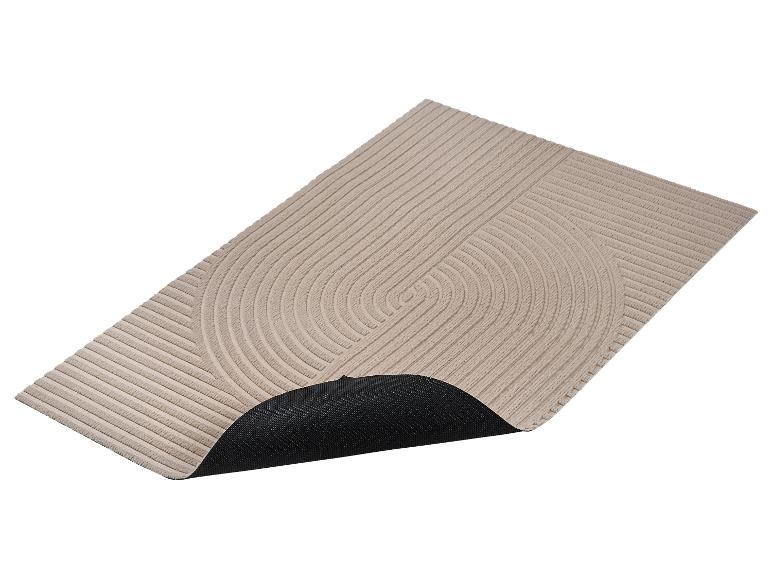 Tapis beige avec motif en relief de rayures et demi-cercles, avec base antidérapante noire.