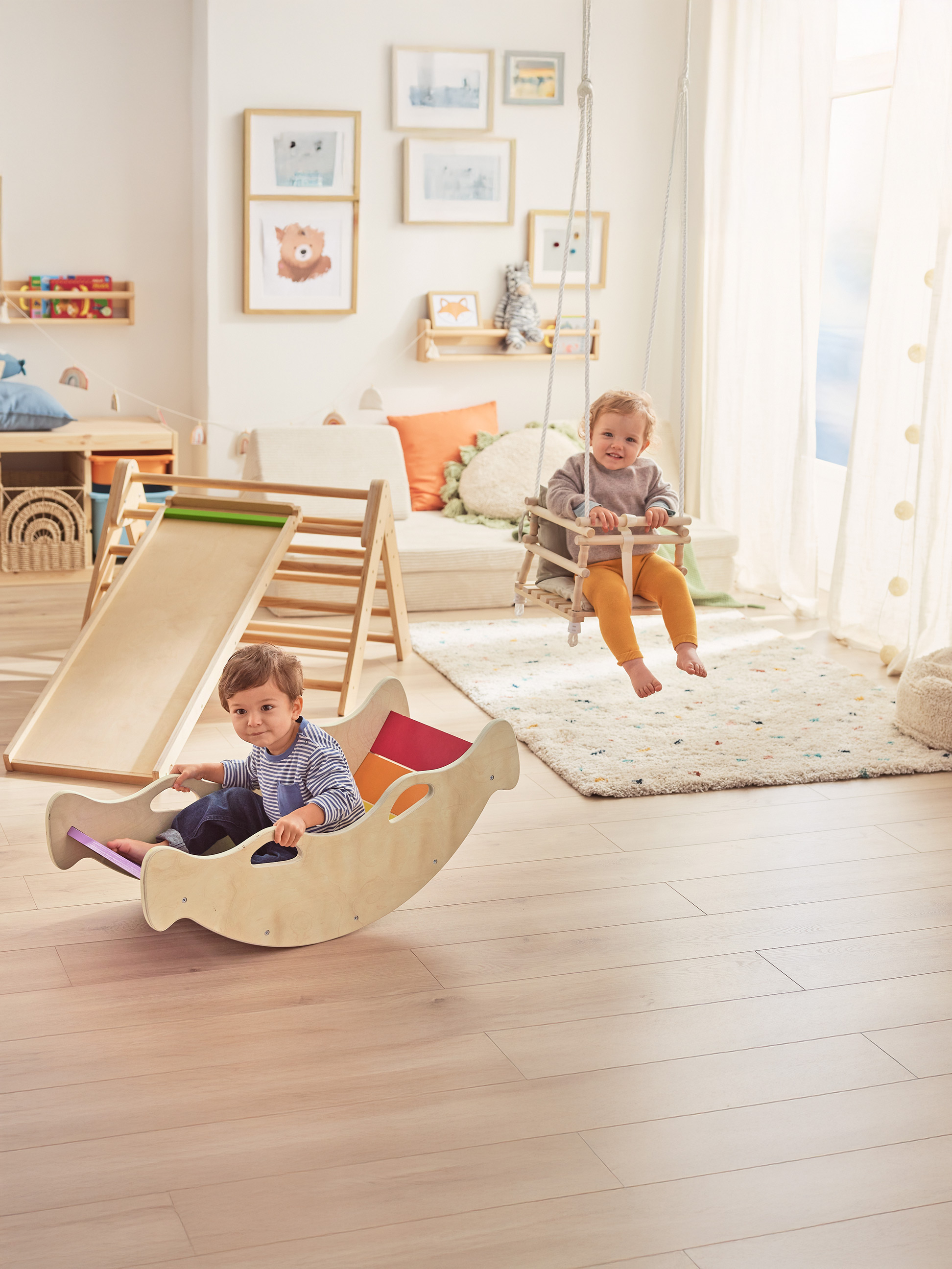 Deux joyeux tout-petits jouent avec des jouets en bois dans une chambre d'enfant lumineuse.