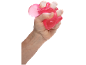 Main serrant un jouet anti-stress rose pailleté.