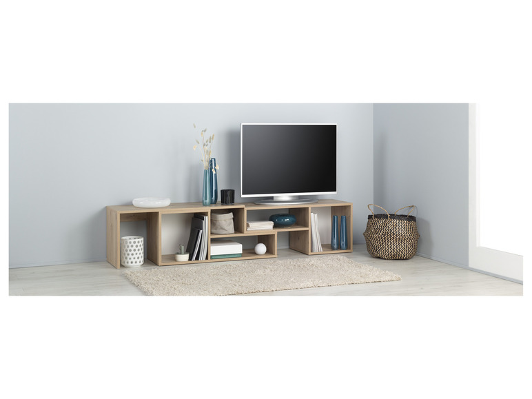 Un meuble TV avec des étagères ouvertes, une télévision et des accessoires décoratifs.