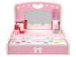 Coiffeuse en bois rose pour enfants avec miroir, tiroir et accessoires de maquillage.