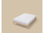 Matelas blanc à rayures sur un cadre de lit en bois.