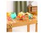 Hochets pour bébé sur le thème de l'ours et un pot de miel sur une table en bois.