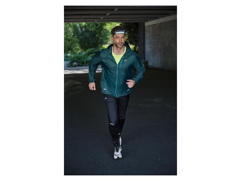 Homme courant en veste de course, pantalon et lampe frontale.