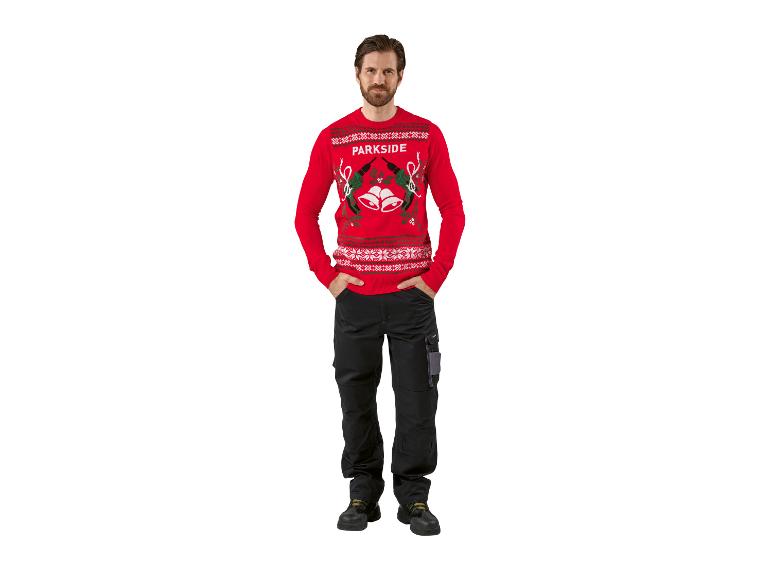 Homme en pull de Noël rouge et pantalon de travail noir.