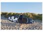 Une femme sur la plage tenant un stand up paddle bleu HOME DELUXE Moana.
