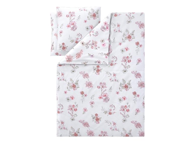 Parure de lit avec housse de couette et taie d'oreiller à motif floral rose et blanc.