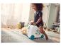 Un enfant joue avec une valise enfant à roulettes décorée de bananes.