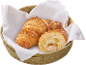 Deux croissants aux noix dans un panier en osier avec une serviette blanche.