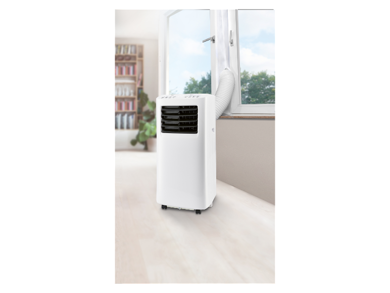 Un climatiseur mobile blanc avec un tuyau d'évacuation, placé près d'une fenêtre.