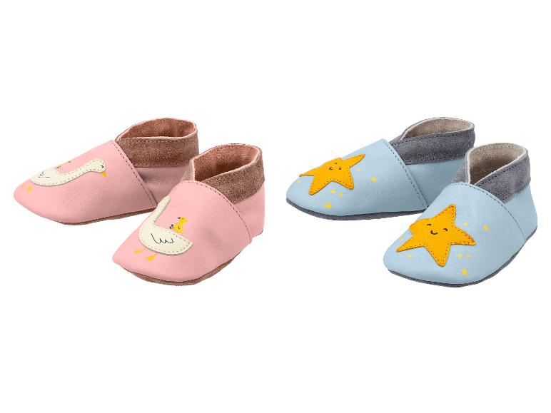 Deux paires de chaussons bébé : roses avec des oies et bleu clair avec des étoiles.