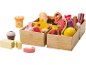 Ensemble de jouets en bois avec fruits, légumes, pain, fromage et viande dans des caisses.