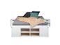 Lit blanc avec matelas gris, couverture beige et oreillers colorés, avec tables de chevet et rangement.
