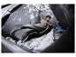 Homme dans une tente de camping avec sac de couchage et matelas, utilisant un smartphone.