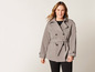 Une femme porte un trench-coat gris.