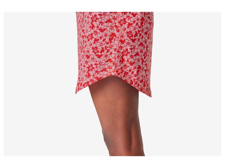 Robe courte à fleurs rouges sur fond rose pâle.