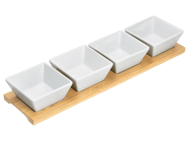 Plateau en bambou avec quatre bols carrés en céramique blanche pour apéritifs.
